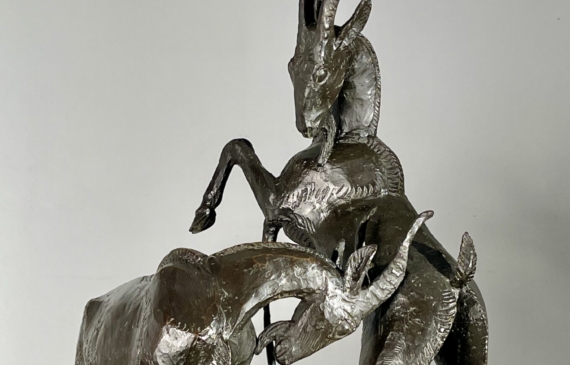 Alt text: Bronze sculpture of two goats