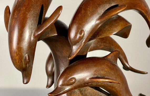 Alt text: Bronze sculpture of a group of dolphins