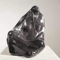 Alt text: Black marble sculpture of a seated woman