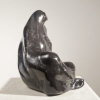 Alt text: Black marble sculpture of a seated woman