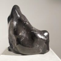 Alt text: Black marble sculpture of a seated woman