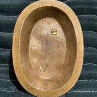Alt text: Bronze relief sculpture, reverse
