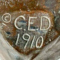 Alt text: Bronze sculpture, signature and date detail