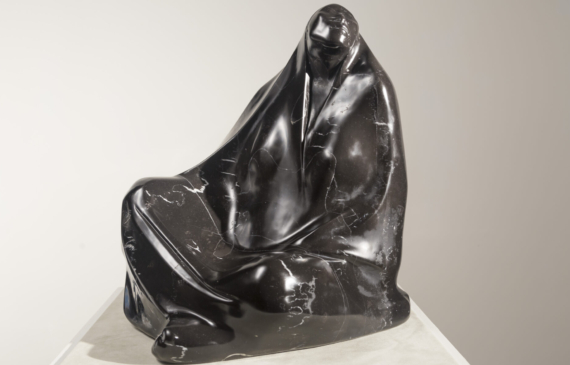 Alt text: Black marble sculpture of a seated woman