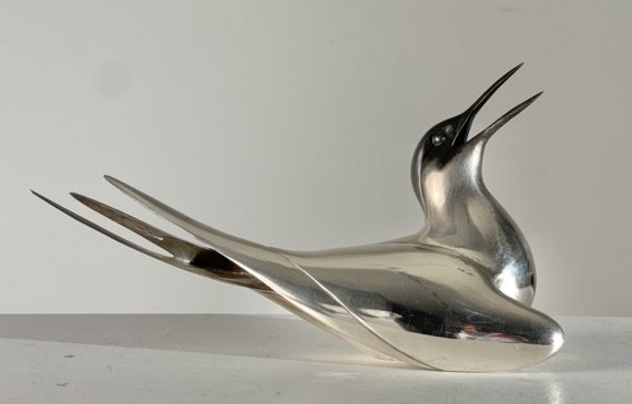 Alt text: Sculpture of a bird with a silver finish