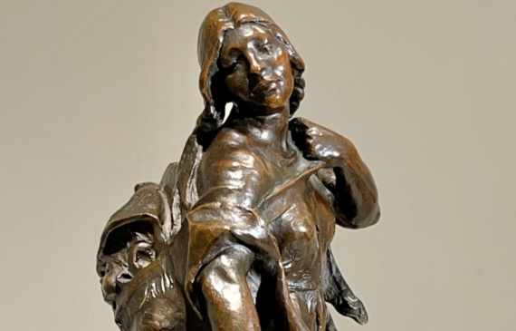 Alt text: Bronze sculpture of a young girl with a baby on her back