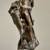 Alt text: Bronze sculpture of a young girl with a baby on her back