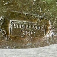 Alt text: Bronze sculpture, foundry mark detail