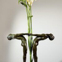 Alt text: Bronze sculpture of two figures holding hands, with flowers between them