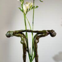 Alt text: Bronze sculpture of two figures holding hands, with flowers between them