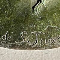 Alt text: Bronze sculpture, signature detail