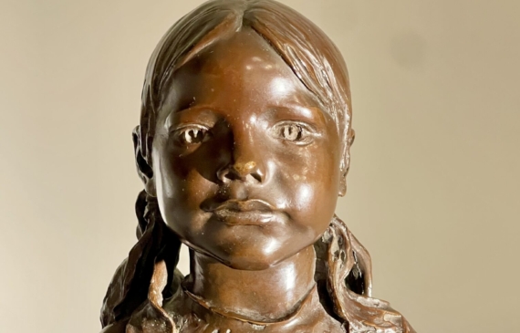 Alt text: Bronze sculpture of a young girl