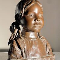 Alt text: Bronze sculpture of a young girl