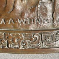 Alt text: Bronze sculpture, signature detail