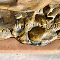 Alt text: Bronze sculpture, signature detail