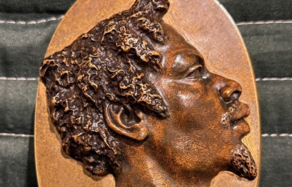 Alt text: Bronze relief sculpture of a man's head