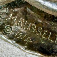 Alt text: Bronze sculpture, signature detail