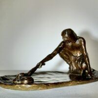 Alt text: Bronze sculpture of a crouching man with outstretched arm