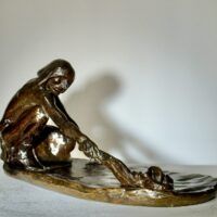 Alt text: Bronze sculpture of a crouching man with outstretched arm