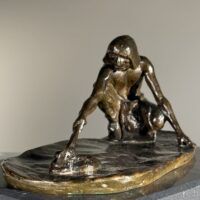 Alt text: Bronze sculpture of a crouching man with outstretched arm