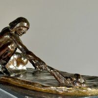 Alt text: Bronze sculpture of a crouching man with outstretched arm