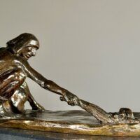 Alt text: Bronze sculpture of a crouching man with outstretched arm