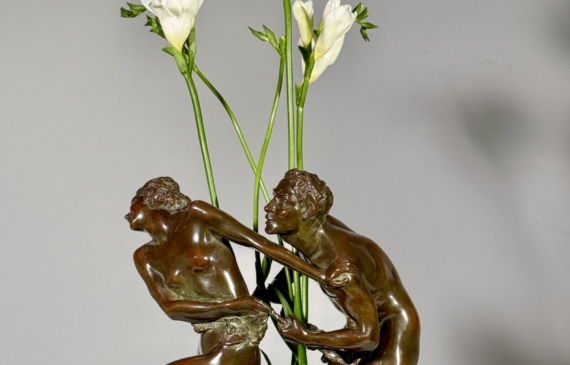 Alt text: Bronze sculpture of two figures with flowers in the center