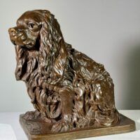 Alt text: Bronze sculpture of a seated dog