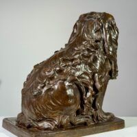 Alt text: Bronze sculpture of a seated dog, back view