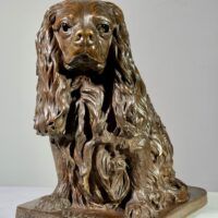 Alt text: Bronze sculpture of a seated dog