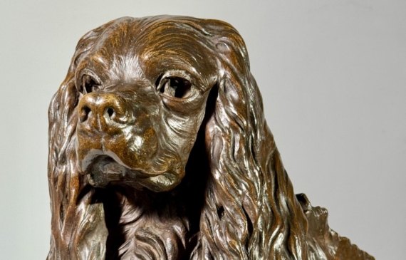 Alt text: Bronze sculpture of a seated dog