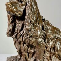 Alt text: Bronze sculpture of a seated dog