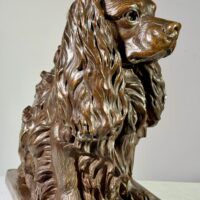 Alt text: Bronze sculpture of a seated dog