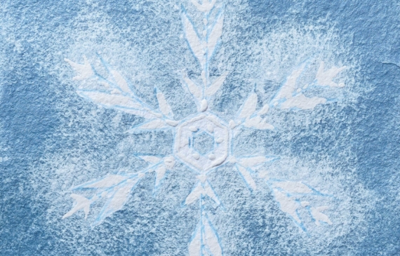 Alt text: watercolor painting of a snowflake in deep blue and white