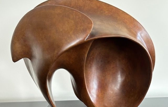 Alt text: Abstract, rounded bronze sculpture