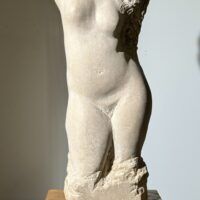 Alt text: Carved stone sculpture of a standing nude woman