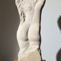 Alt text: Carved stone sculpture of a standing nude woman