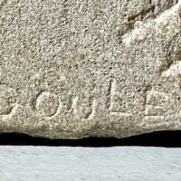 Alt text: Stone sculpture, signature detail