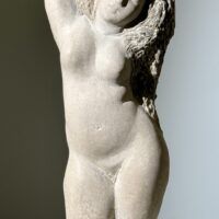 Alt text: Carved stone sculpture of a standing nude woman