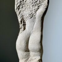 Alt text: Carved stone sculpture of a standing nude woman