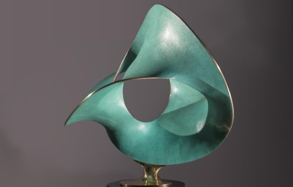 Alt text: Polished bronze sculpture of three warped circles