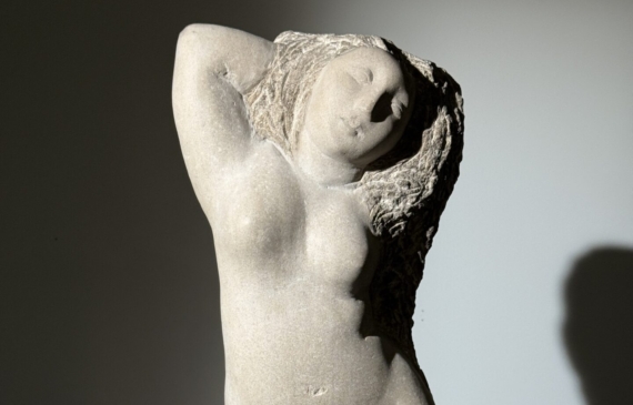 Alt text: Carved stone sculpture of a standing nude woman
