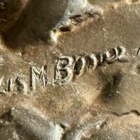 Alt text: Bronze sculpture, signature detail