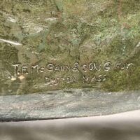Alt text: Bronze sculpture, foundry mark detail