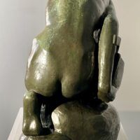 Alt text: Bronze sculpture of a crouching boy holding a sailboat