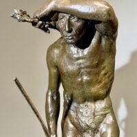 Alt text: Bronze sculpture of a Native American man looking into the distance, detail