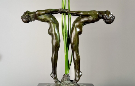 Alt text: Bronze sculpture of two figures holding hands, with flowers between them